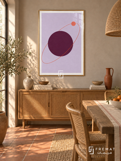 Plum Orbit. A coral orbit and small disk circle a large plum sphere on lavender. Shown in a Gold PVC frame in a styled room.