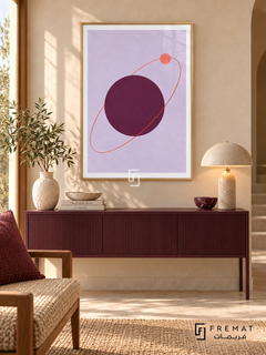 Plum Orbit. A coral orbit and small disk circle a large plum sphere on lavender. Shown in a Wooden Texture PVC frame in a styled room.