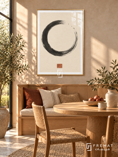 Ink Stillness. A charcoal dry-brush circle and small terracotta square create a spare composition on warm ivory. Shown in a Gold PVC frame in a styled room.
