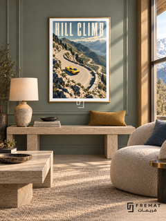Hill Climb (car09), Gold frame with white printed border in a styled interior. A yellow sports car rounds a pale winding mountain road above a blue lake, rocky slopes and evergreen trees. Tall cream lettering reads HILL CLIMB.