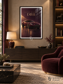 Aston Martin DB11 (car19), Black frame with white printed border in a styled interior. A burgundy Aston Martin DB11 sits on a glossy dark floor under a warm diagonal shaft of light. Gold-toned ASTON MARTIN DB11 lettering completes the wine-red composition.