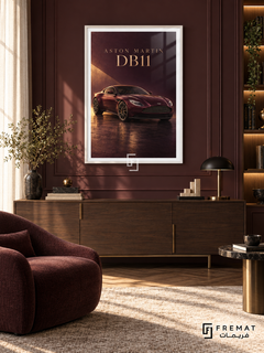 Aston Martin DB11 (car19), White frame with white printed border in a styled interior. A burgundy Aston Martin DB11 sits on a glossy dark floor under a warm diagonal shaft of light. Gold-toned ASTON MARTIN DB11 lettering completes the wine-red composition.