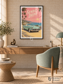 Sunday Drive (car22), Black frame with white printed border in a styled interior. A mint-green vintage convertible stands on a sunny coastal road beneath palm trees and a pink sunset sky. Cream slanted lettering reads SUNDAY DRIVE.