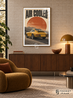 Air Cooled (car26), Gold frame with white printed border in a styled interior. A mustard-yellow classic coupe is shown from the rear against layered mountains and a large rust-orange sun. Curved black lettering reads AIR COOLED on warm cream paper.