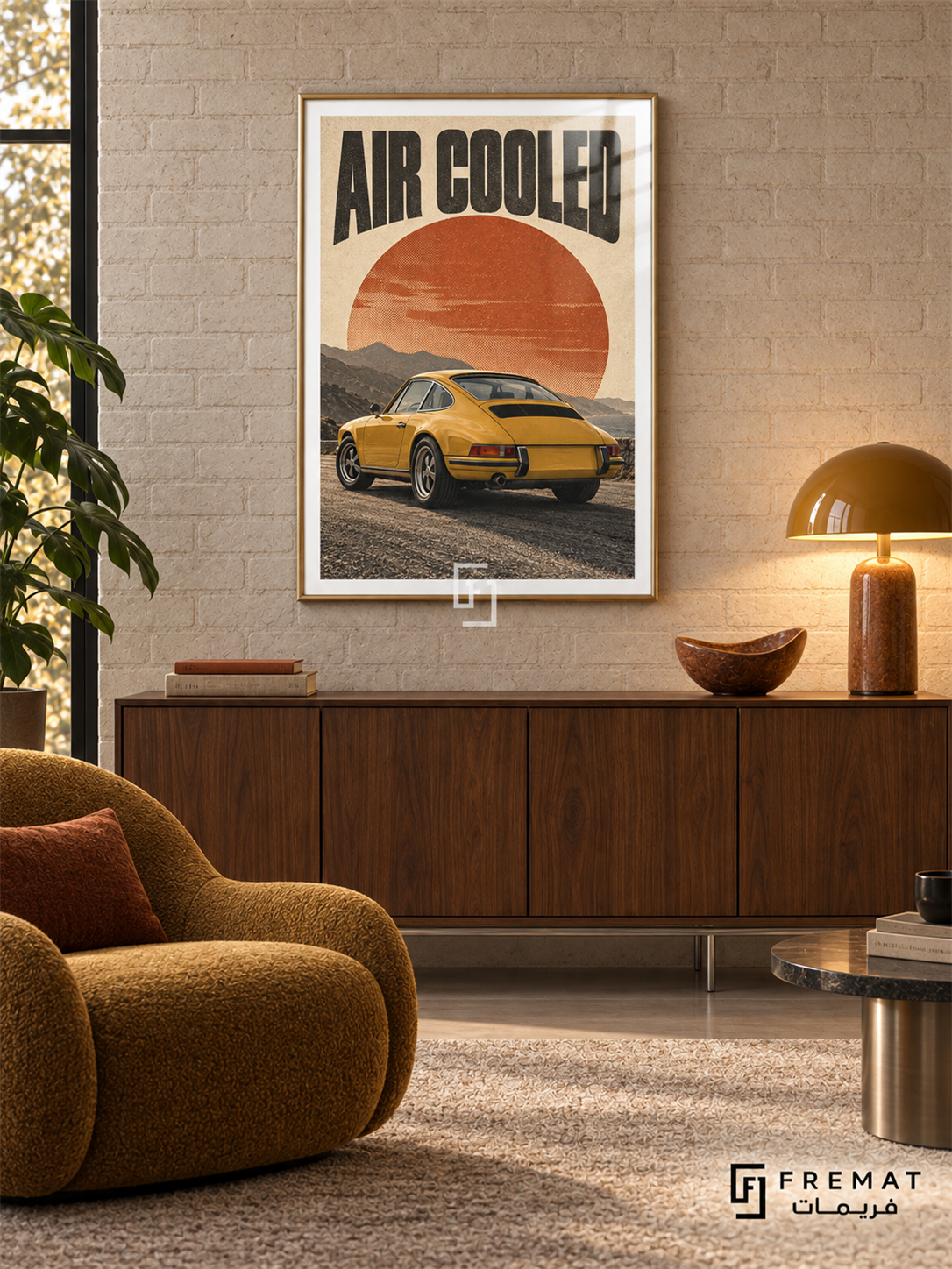 Air Cooled (car26), Gold frame with white printed border in a styled interior. A mustard-yellow classic coupe is shown from the rear against layered mountains and a large rust-orange sun. Curved black lettering reads AIR COOLED on warm cream paper.