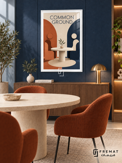 Common Ground (com06), White frame with white printed border in a styled interior. Two simplified seated figures face each other across a round table with a leafy sprig. Terracotta and navy arches frame the cream scene beneath “COMMON GROUND” in a geometric sculptural illustration.