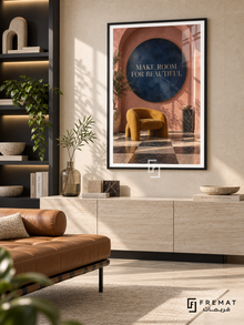Make Room for Beautiful (com18), Black frame with white printed border in a styled interior. A mustard sculptural chair sits beneath a navy circle inside a terracotta arch, with a checkerboard floor and leafy shadows. Small gold lettering reads “MAKE ROOM FOR BEAUTIFUL”.