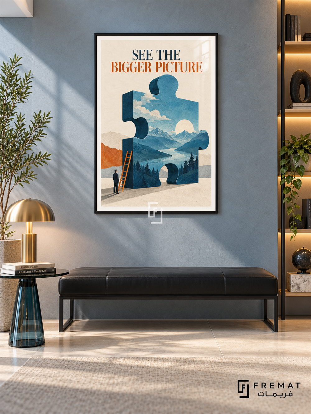 See the Bigger Picture (com21), Black frame with white printed border in a styled interior. A large blue puzzle piece contains mountains, trees, water and clouds beside a small figure and orange ladder. Navy and rust lettering reads “SEE THE BIGGER PICTURE” on cream.