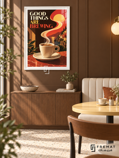 Good Things Are Brewing (com27), White frame with white printed border in a styled interior. Steam rises from a cream coffee cup into a winding sunset above a hillside town and water. Cream and red “GOOD THINGS ARE BREWING” lettering contrasts with warm orange and dark brown.