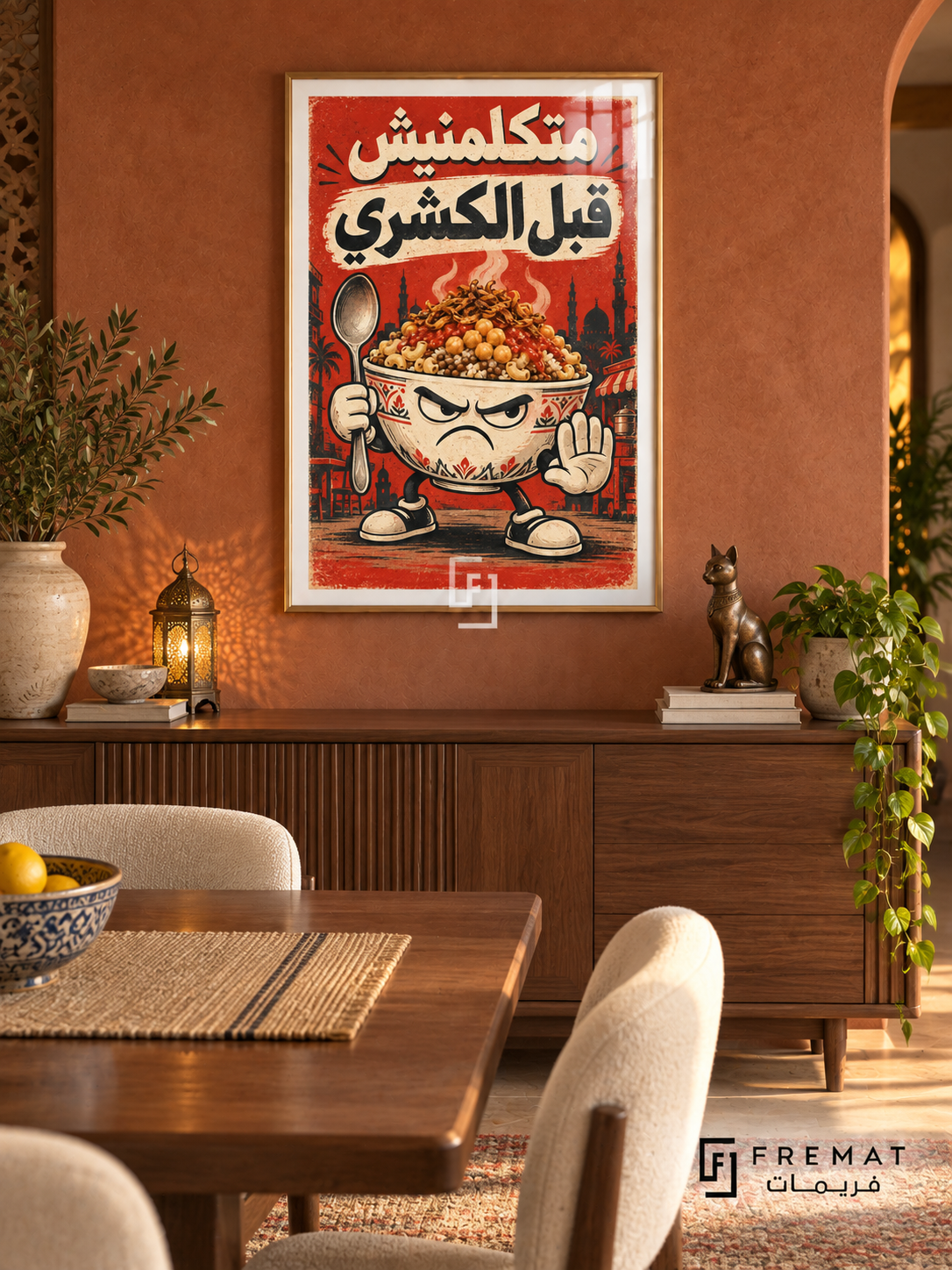 Koshary First (fun19) — Gold frame, white paper border and FREMAT branding in a styled interior. A grumpy koshary bowl holds a spoon and raises a hand, with pasta, chickpeas and onions piled high. Egyptian Arabic reads “متكلمنيش قبل الكشري” in cream and charcoal over tomato red.