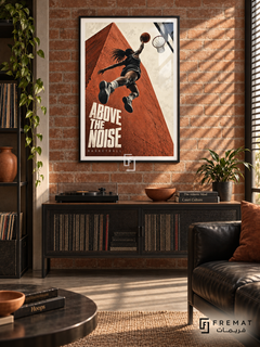 Above The Noise: A basketball player rises toward a hoop against terracotta architecture and a cream sky, with bold editorial lettering. Black frame with a white printed border, displayed in a styled room.