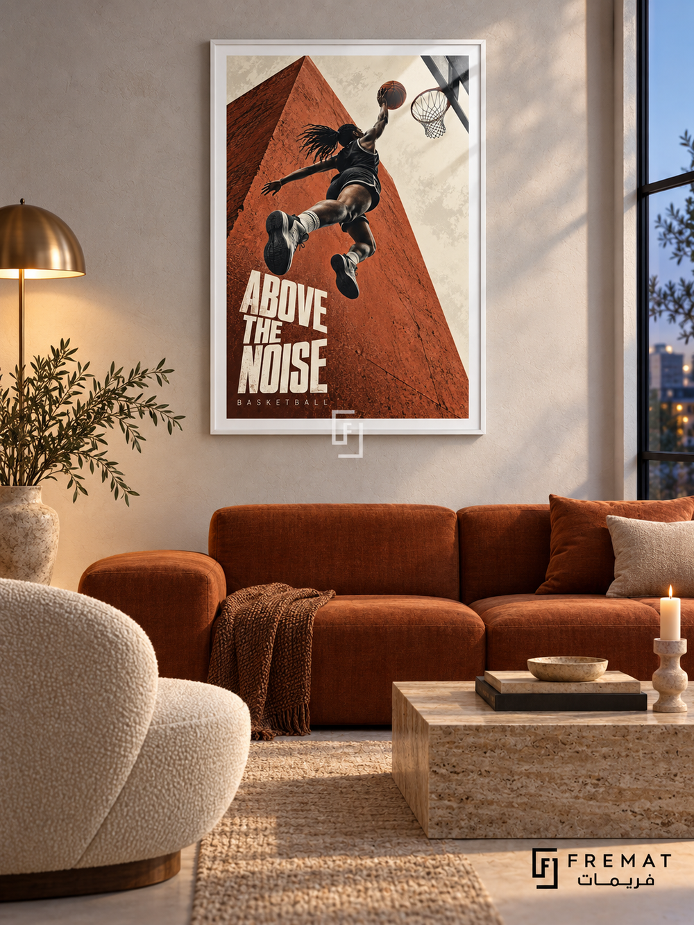 Above The Noise: A basketball player rises toward a hoop against terracotta architecture and a cream sky, with bold editorial lettering. White frame with a white printed border, displayed in a styled room.
