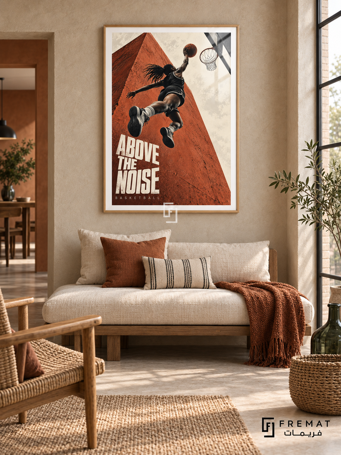 Above The Noise: A basketball player rises toward a hoop against terracotta architecture and a cream sky, with bold editorial lettering. Wooden Texture frame with a white printed border, displayed in a styled room.