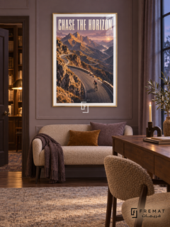 Chase The Horizon: A cyclist follows a winding mountain road through ochre peaks and lavender sky in a textured landscape illustration. Gold frame with a white printed border, displayed in a styled room.