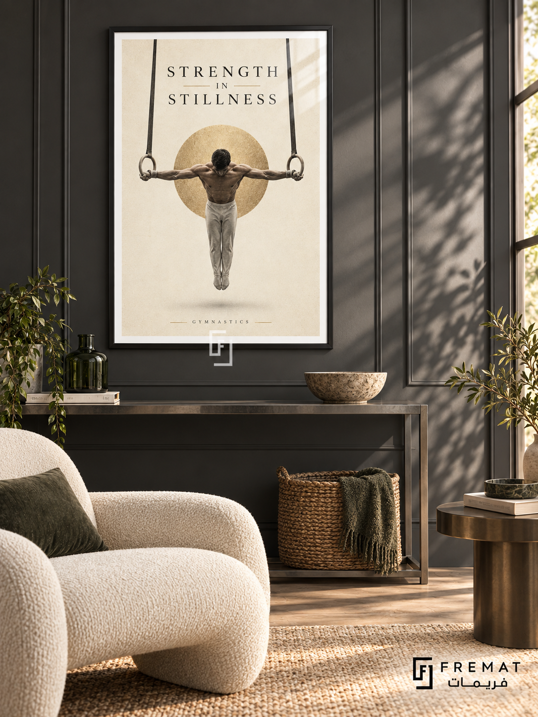 Strength In Stillness: A gymnast holds a rings pose against warm ivory space, a soft charcoal shadow and a subtle gold disc. Black frame with a white printed border, displayed in a styled room.