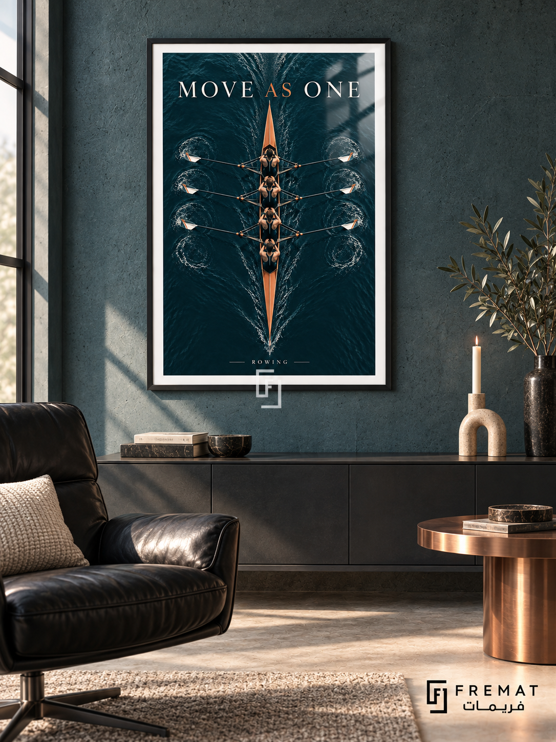 Move As One: An overhead rowing shell crosses dark petrol-colored water, surrounded by fine ripples and synchronized oars. Black frame with a white printed border, displayed in a styled room.